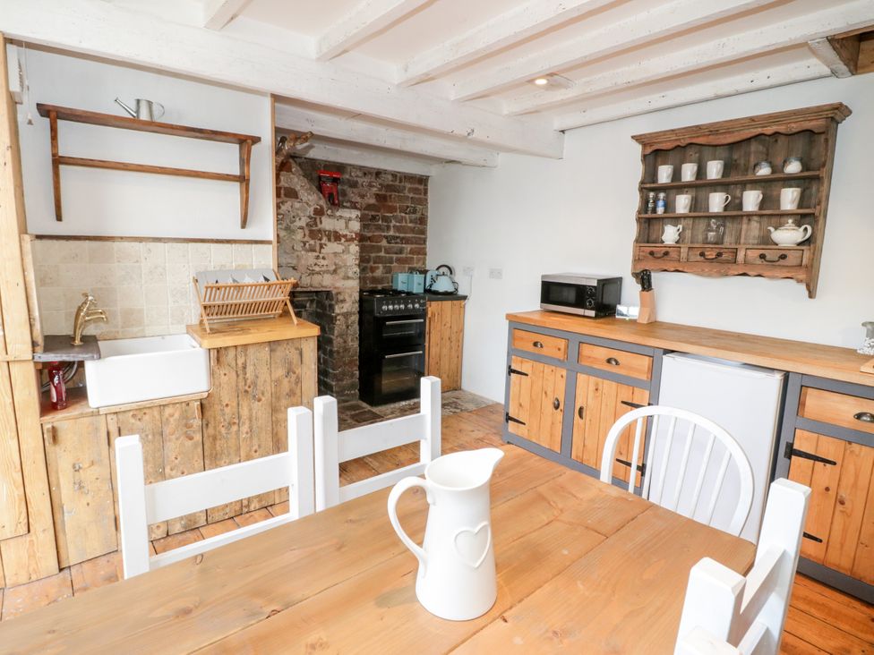 A kitchen with wooden cabinets and appliances at Studio Bach in Beaumaris