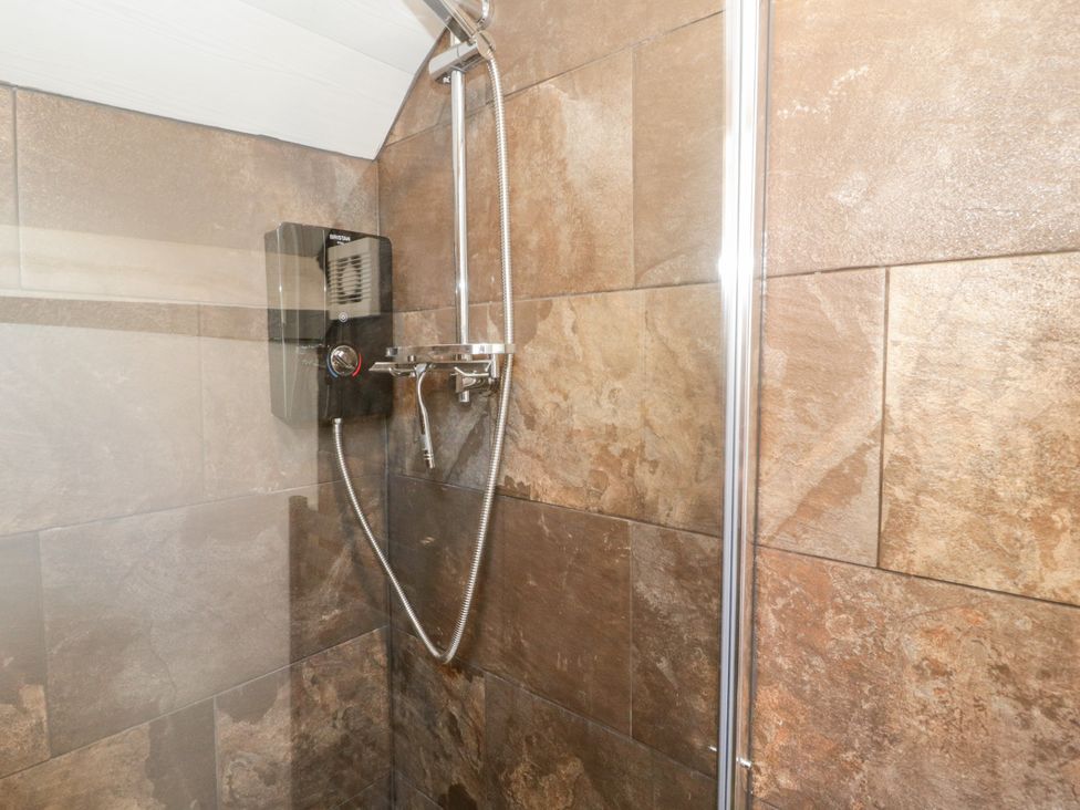 A shower with tiles and controls at Studio Bach Beaumaris