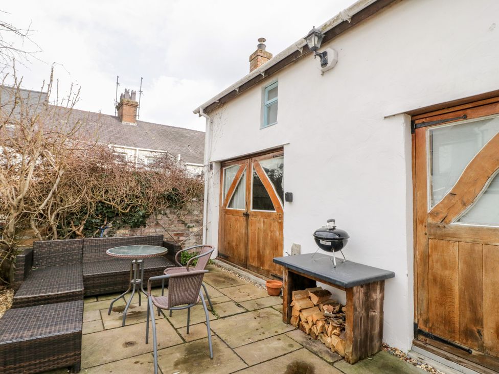 A garden with seating and a barbecue grill at Studio Bach in Beaumaris