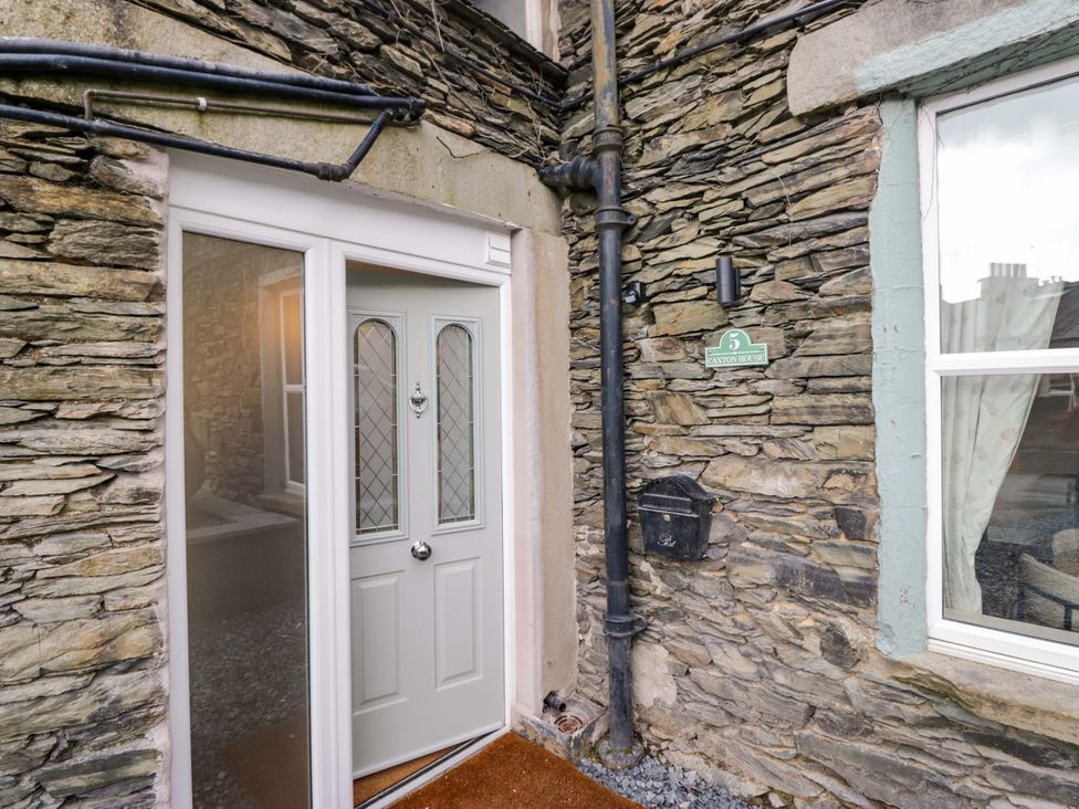 An entrance with a door and stone wall at Flat 5 Caxton House Windermere