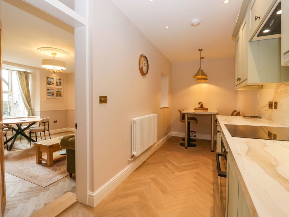 A kitchen with a stool and a table at Flat 5 Caxton House in Windermere