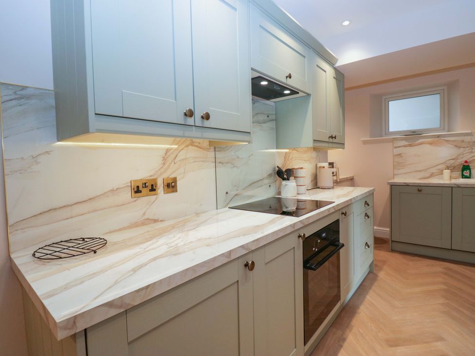 A kitchen with cabinets, countertop, and appliances at Flat 5 Caxton House in Windermere