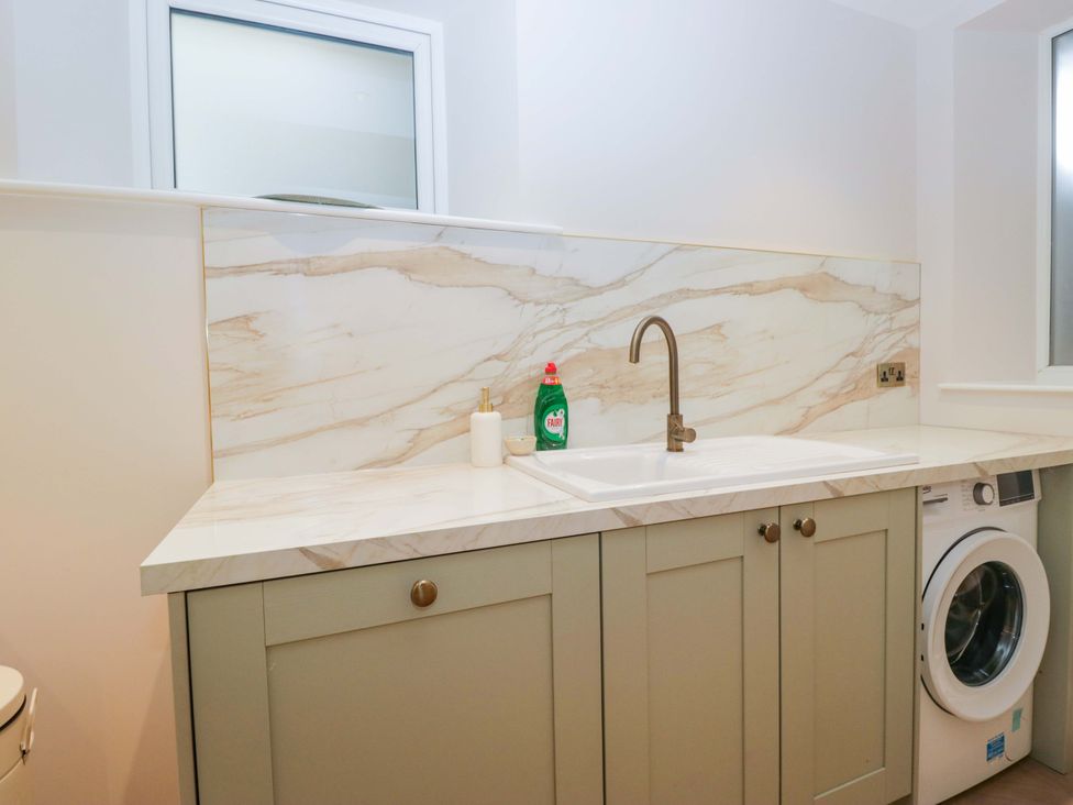 A laundry room with a sink and washing machine at Flat 5 Caxton House in Windermere