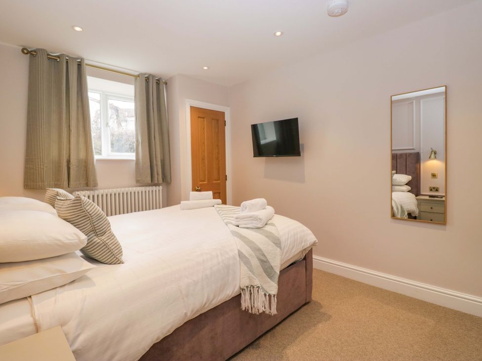 A bedroom with a bed and television at Flat 5 Caxton House Windermere
