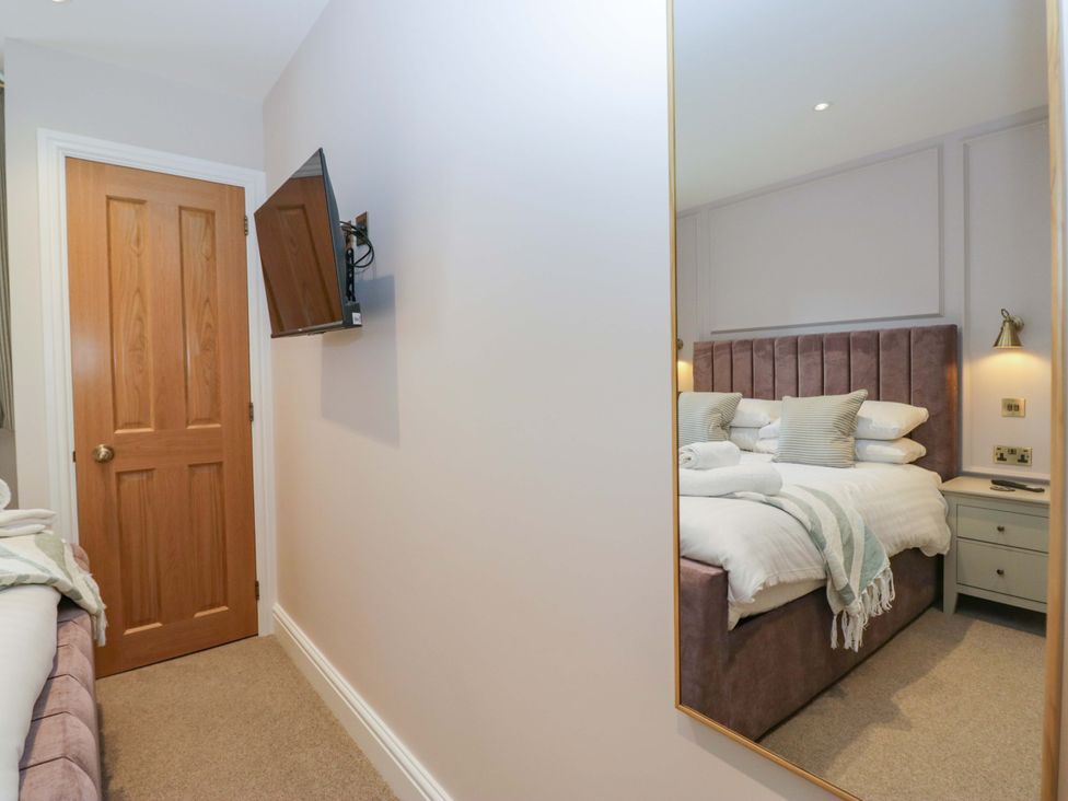 A bedroom with a bed and a television at Flat 5 Caxton House Windermere
