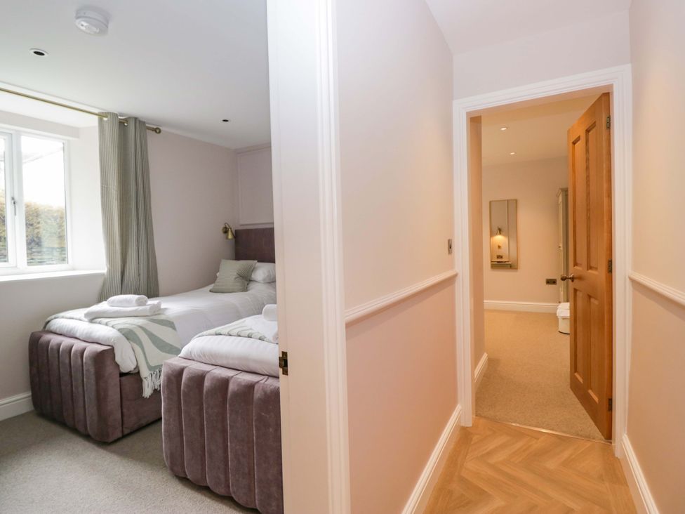A bedroom with two beds and a window at Flat 5 Caxton House Windermere