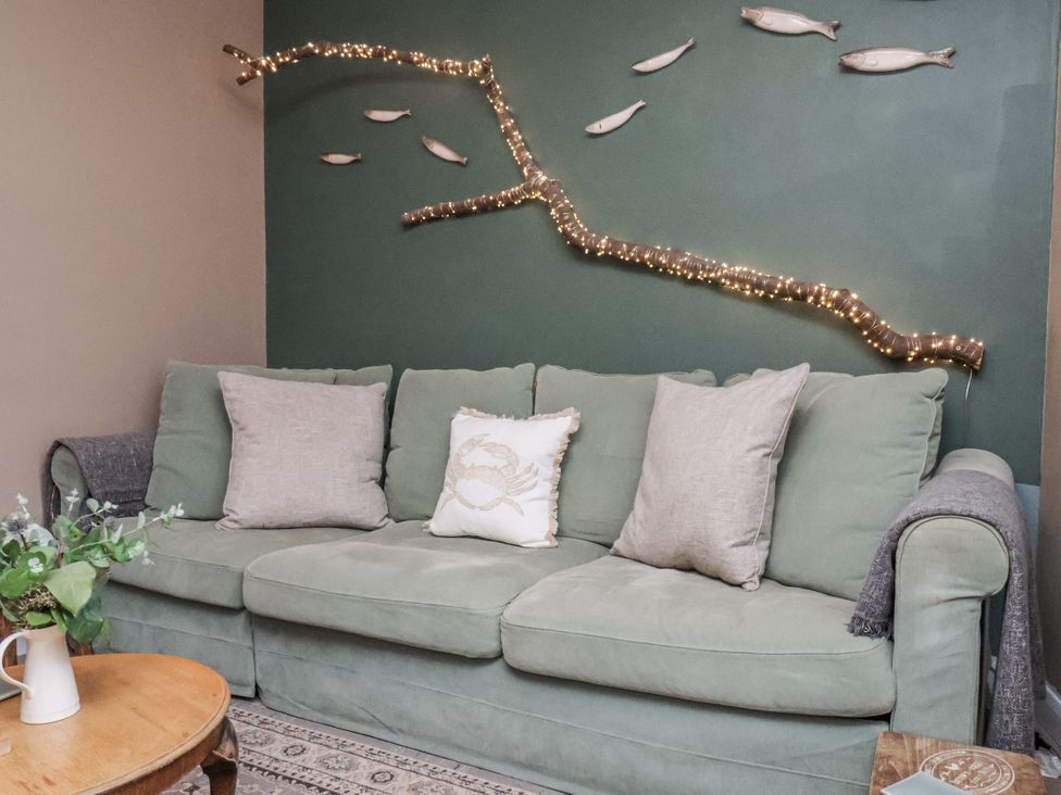 A living room with a sofa and decorative elements at Albion Cottage in Whitby