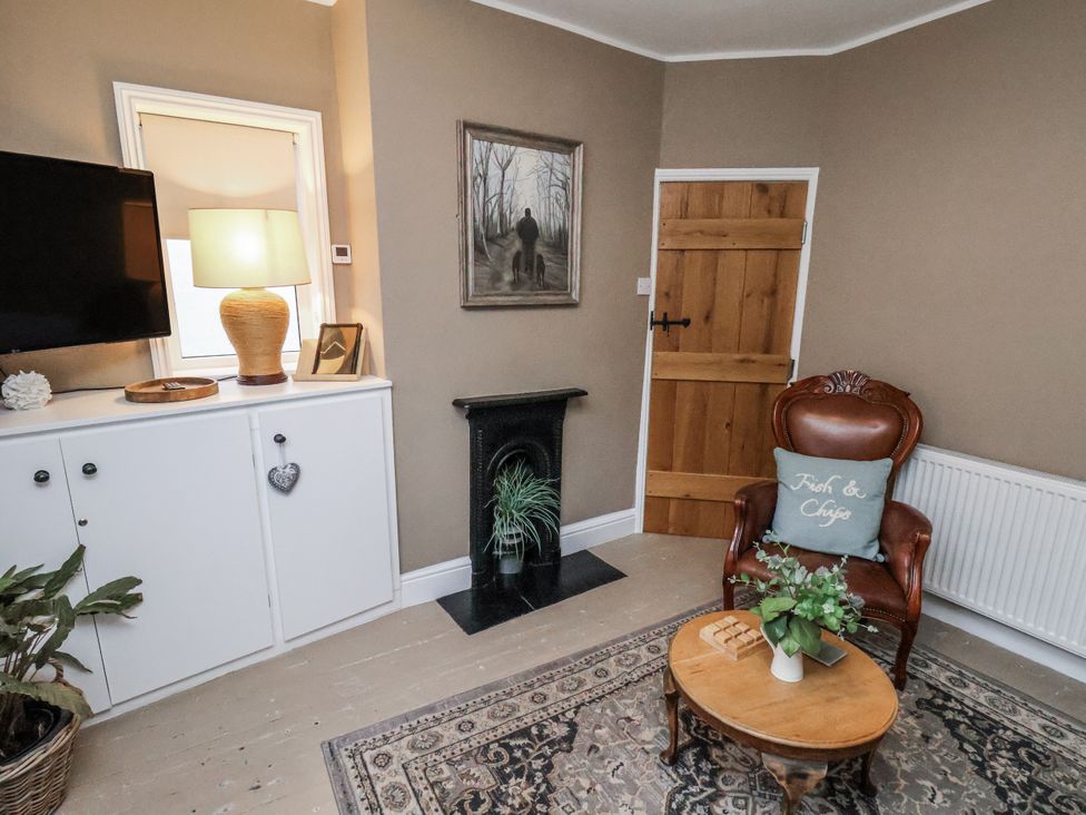 A living room with a coffee table and armchair at Albion Cottage in Whitby