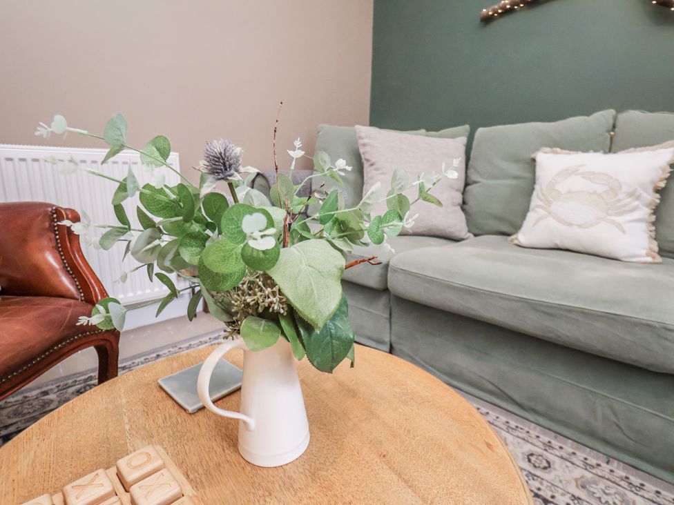A living room with a sofa and armchair at Albion Cottage in Whitby