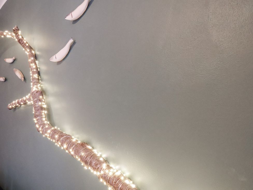A decorative wall with lights and fish ornaments at Albion Cottage in Whitby