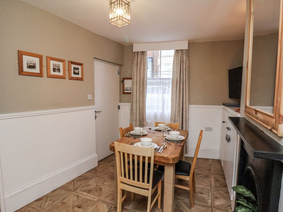 A dining room with a table set for meals at Albion Cottage in Whitby