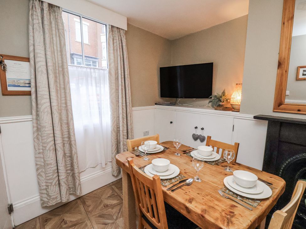 A dining room with a table set for dinner at Albion Cottage in Whitby