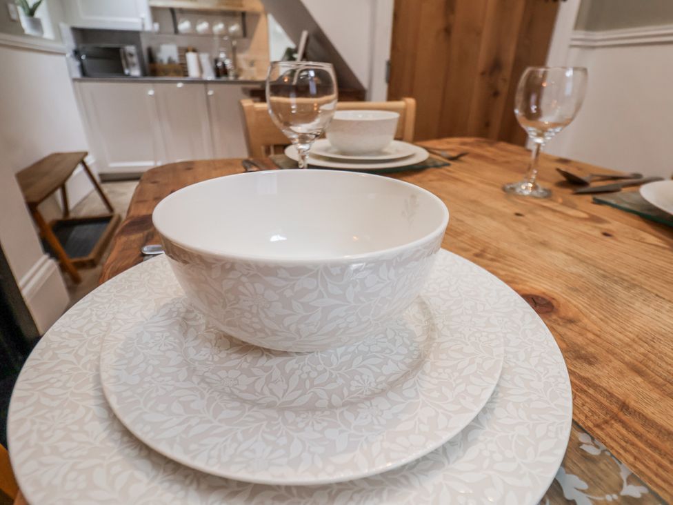 A dining table set with cutlery and dishware at Albion Cottage Whitby