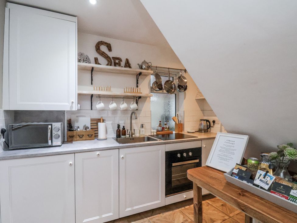 A kitchen with cabinets and appliances at Albion Cottage in Whitby