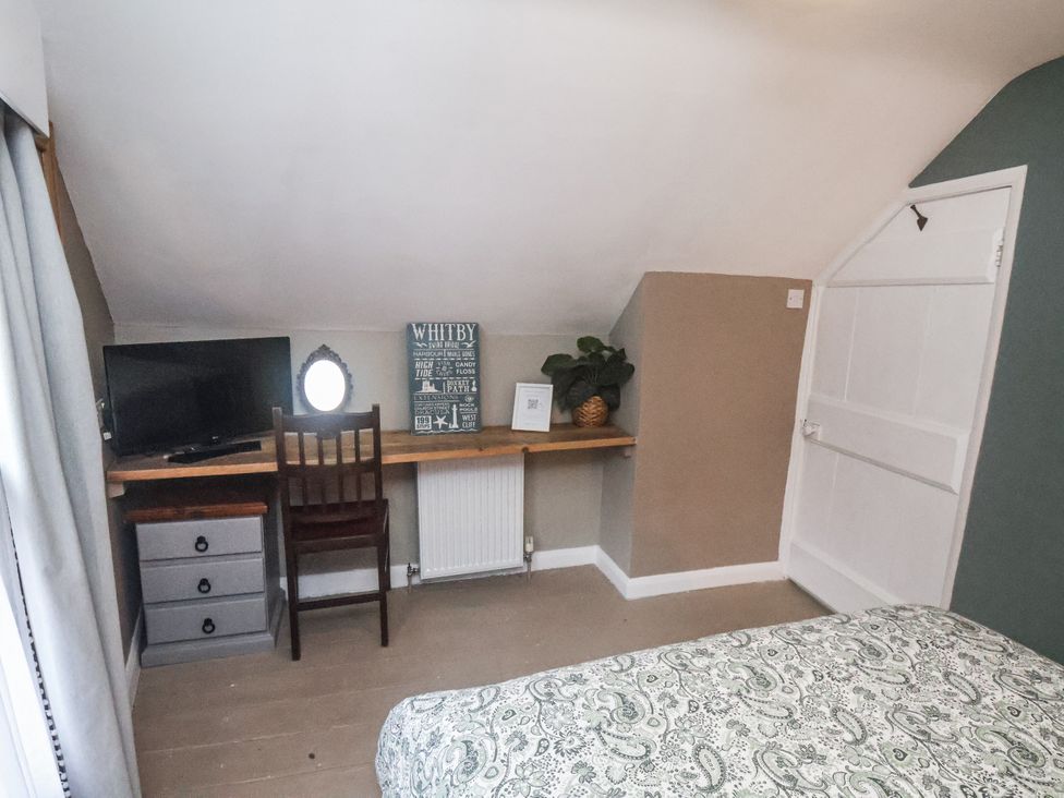 A bedroom with a desk and television at Albion Cottage in Whitby