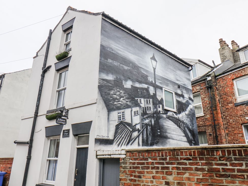 A building with a mural and sign at Albion Cottage in Whitby