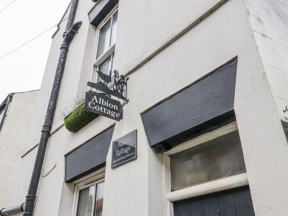A building exterior with a sign and window at Albion Cottage in Whitby