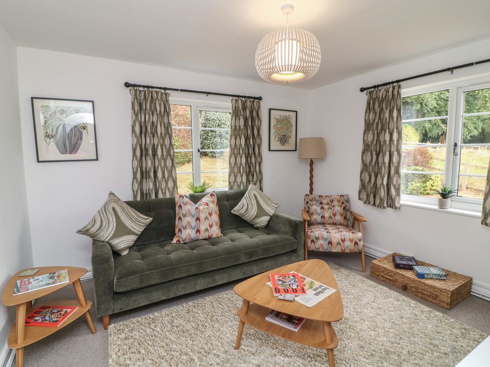A living room with a sofa and coffee table at Casthorpe Lodge Cottage in Barrowby