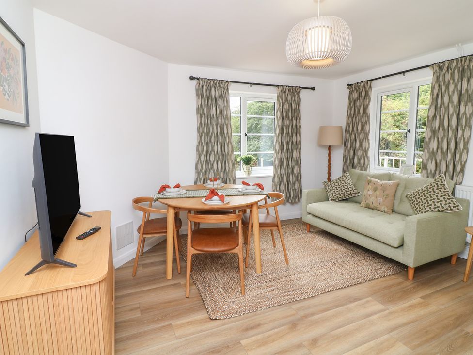 A living room with a sofa and dining table at Casthorpe Lodge Cottage Barrowby