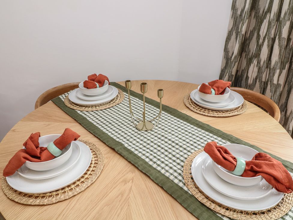 A dining table set with plates and napkins at Casthorpe Lodge Cottage Barrowby