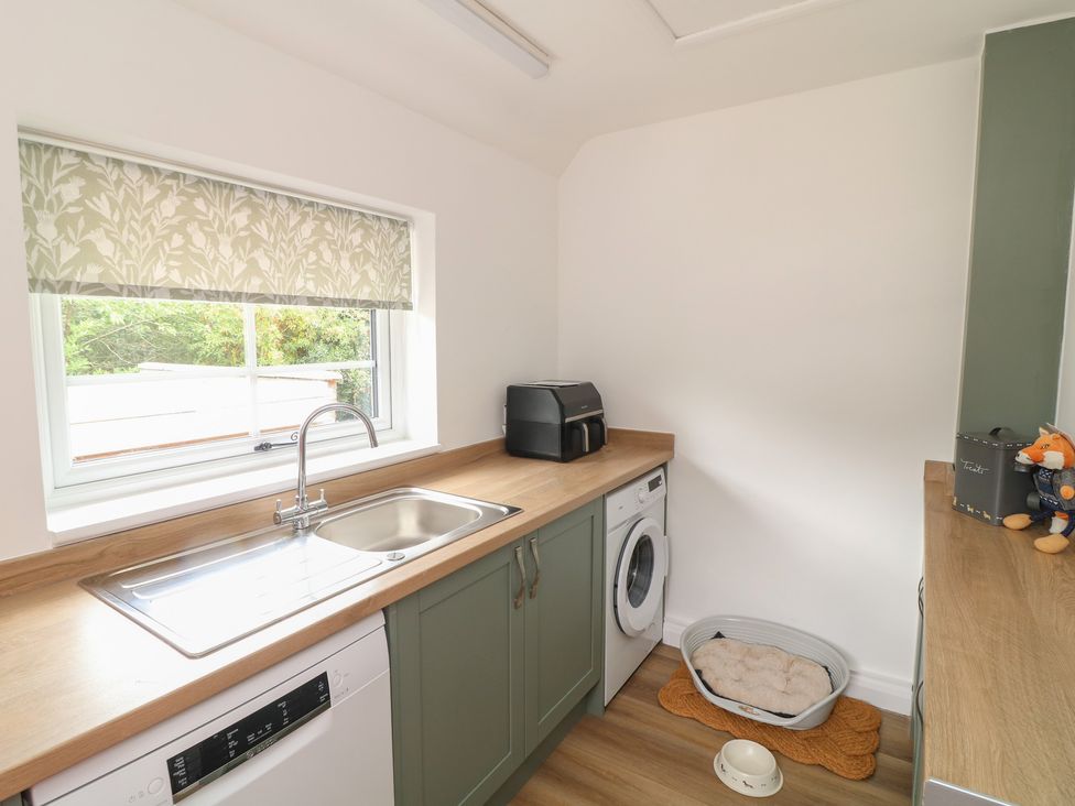 A kitchen with sink and washing machine at Casthorpe Lodge Cottage in Barrowby