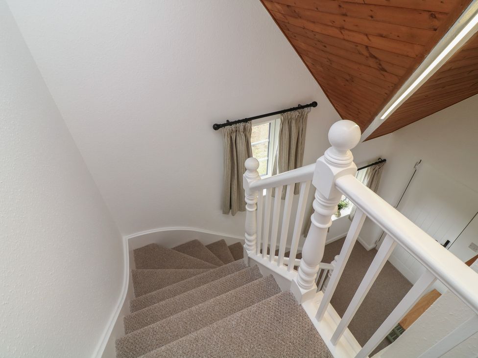 A staircase with a window and curtains at Casthorpe Lodge Cottage Barrowby