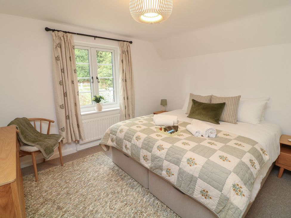 A bedroom with bed, side table, and chair at Casthorpe Lodge Cottage Barrowby