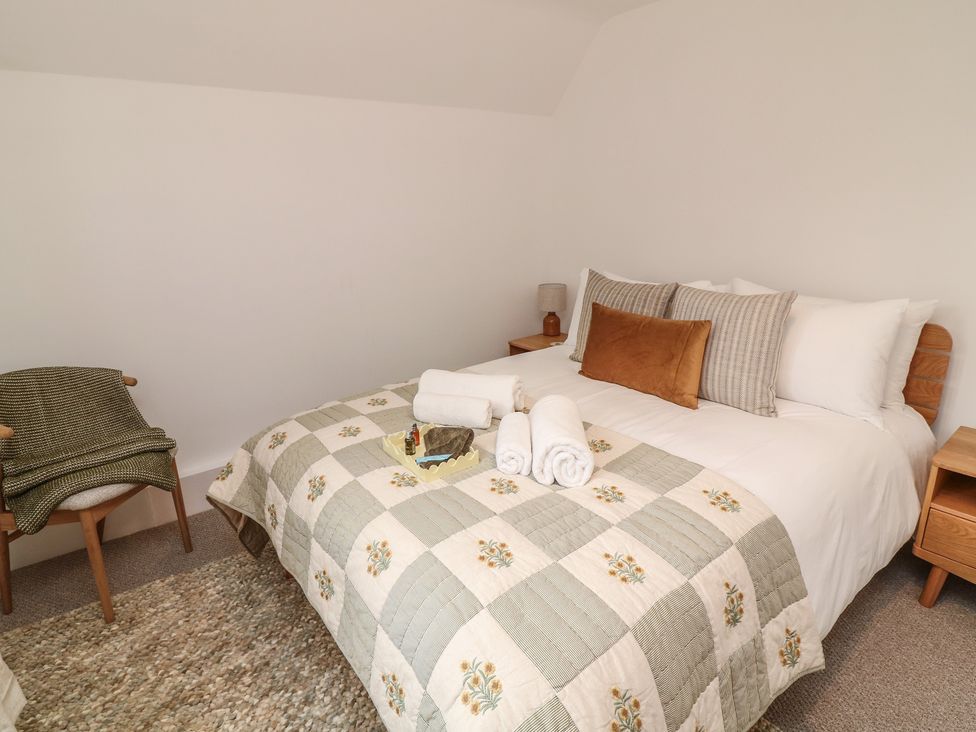 A bedroom featuring a bed with pillows and towels at Casthorpe Lodge Cottage Barrowby