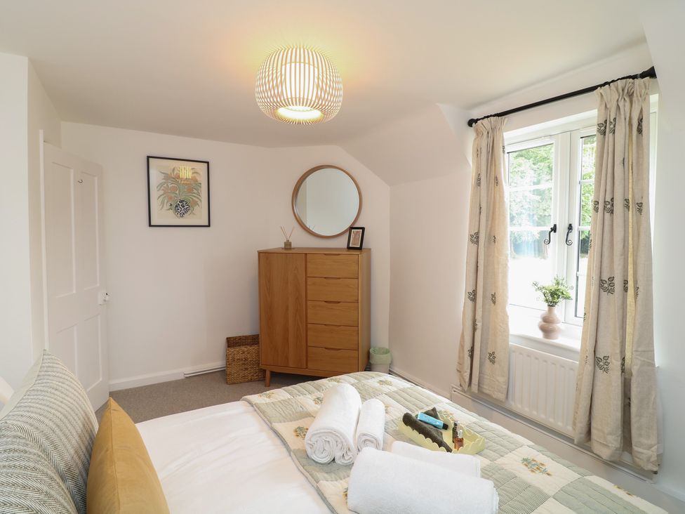 A bedroom featuring a bed with towels and a wardrobe at Casthorpe Lodge Cottage Barrowby