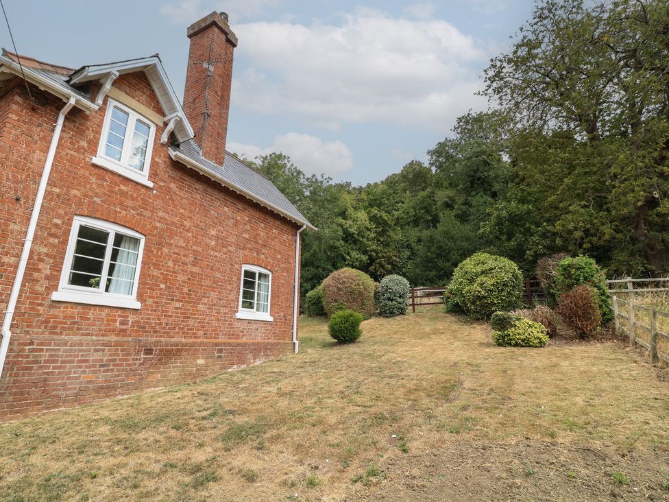 A house exterior with a lawn and bushes at Casthorpe Lodge Cottage Barrowby