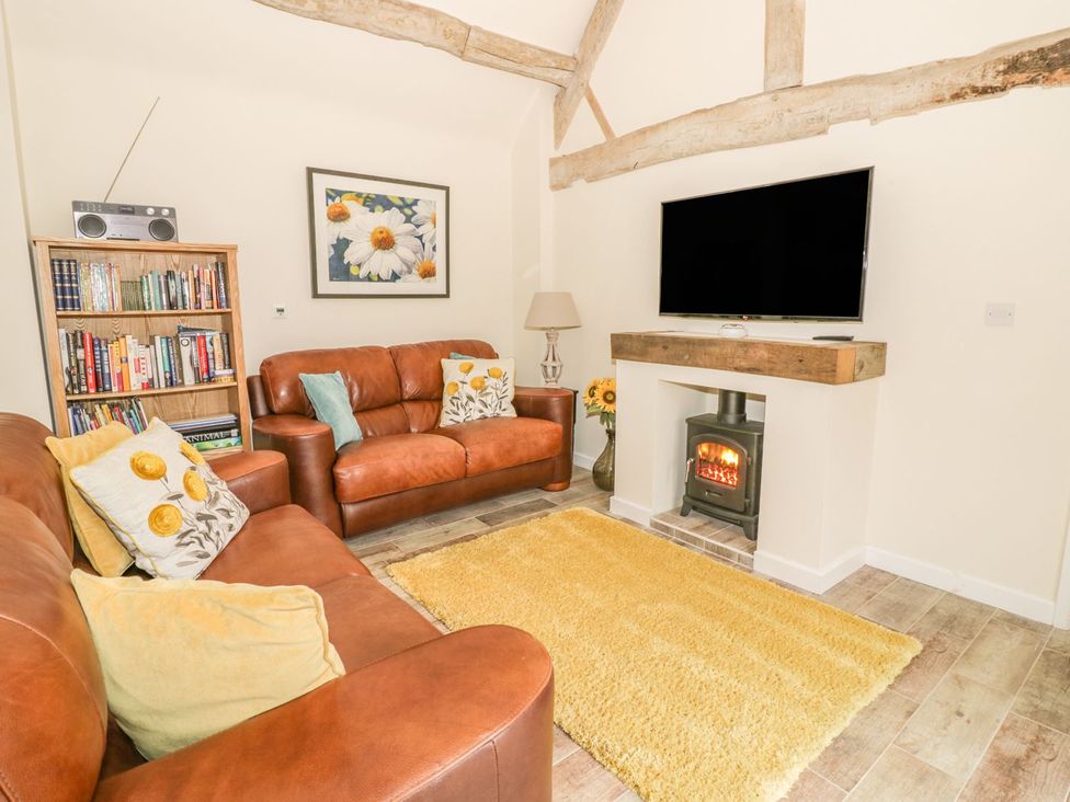 A living room with a television and fireplace at Megs Cottage in Stratford-upon-Avon