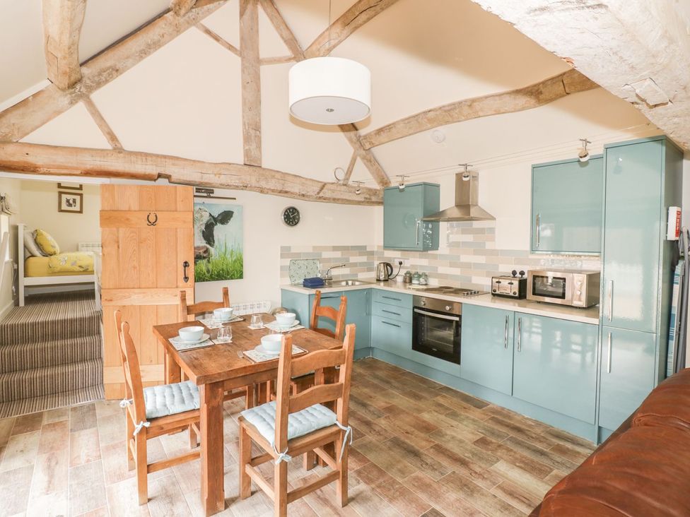 A kitchen with a dining table and appliances at Megs Cottage in Stratford-upon-Avon