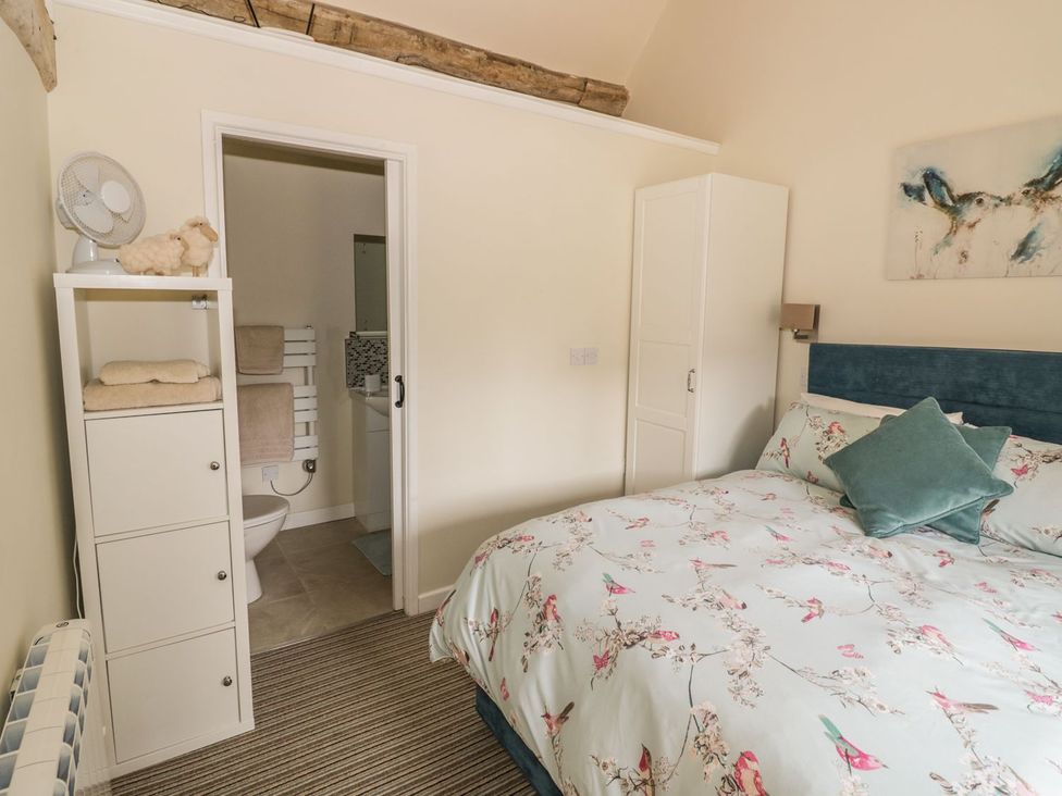 A bedroom with a bed and adjoining bathroom at Megs Cottage Stratford-upon-Avon
