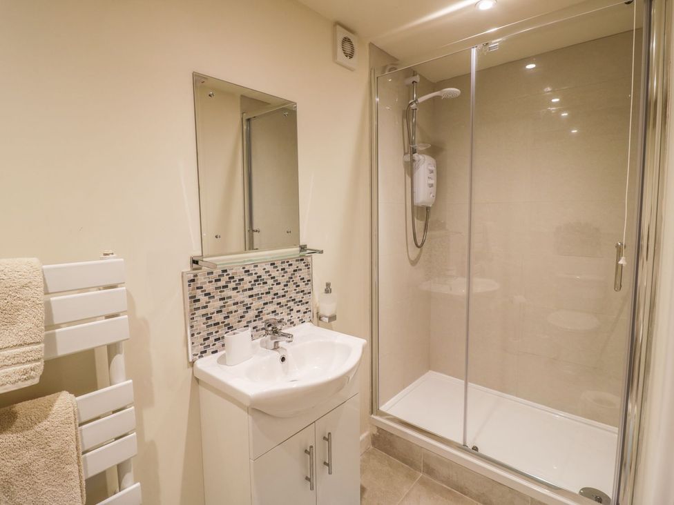 A bathroom with a shower and wash basin at Megs Cottage in Stratford-upon-Avon