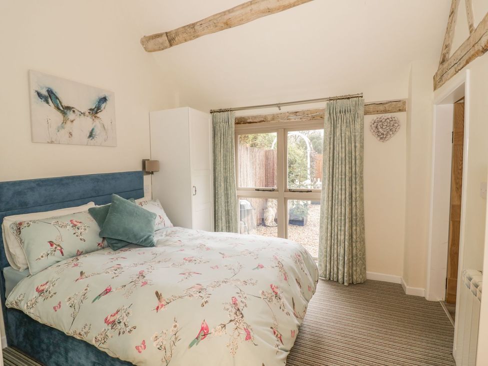 A bedroom with a bed and wardrobe at Megs Cottage in Stratford-upon-Avon