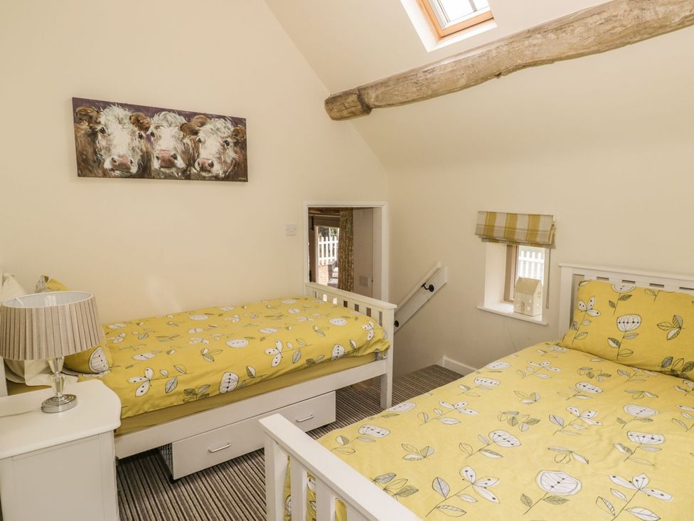 A bedroom with two beds and a staircase at Megs Cottage in Stratford-upon-Avon
