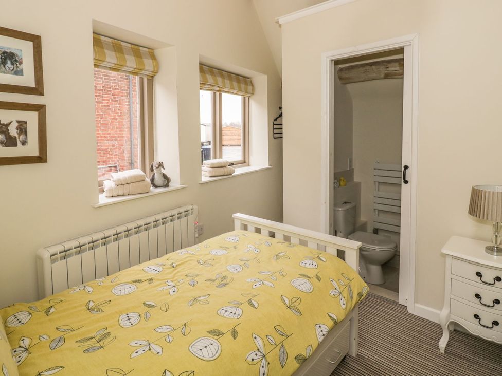 A bedroom with a bed and an attached bathroom at Megs Cottage in Stratford-upon-Avon