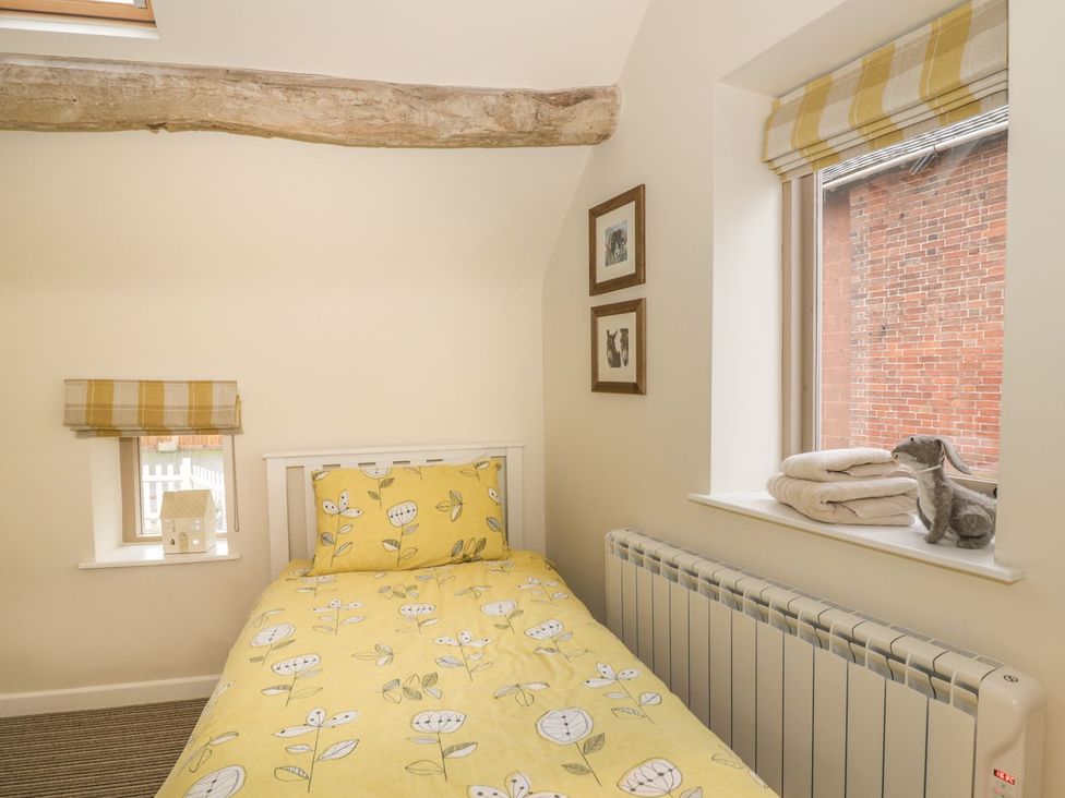 A bedroom with a bed and window at Megs Cottage Stratford-upon-Avon
