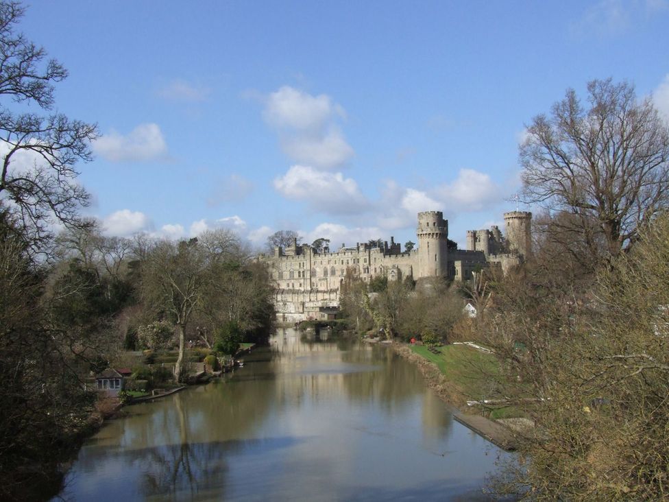 A view of a castle beside a river at Megs Cottage in Stratford-upon-Avon