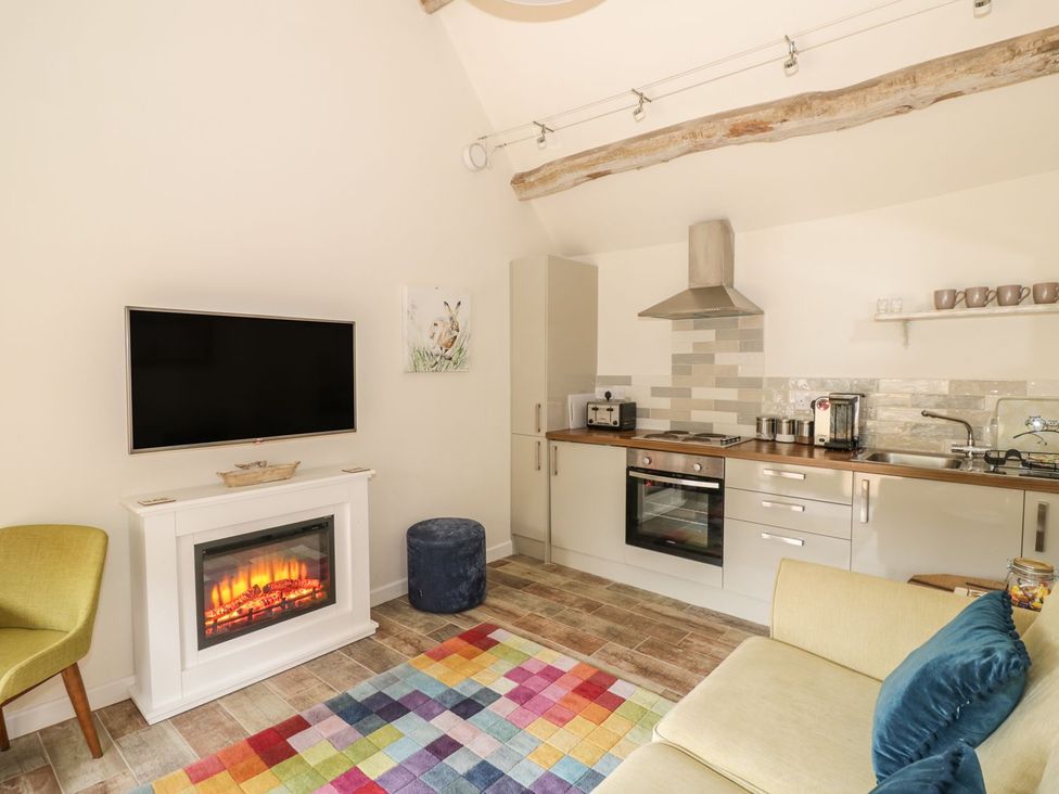 A living room with a television and a fireplace at The Bolt Hole in Stratford-upon-Avon