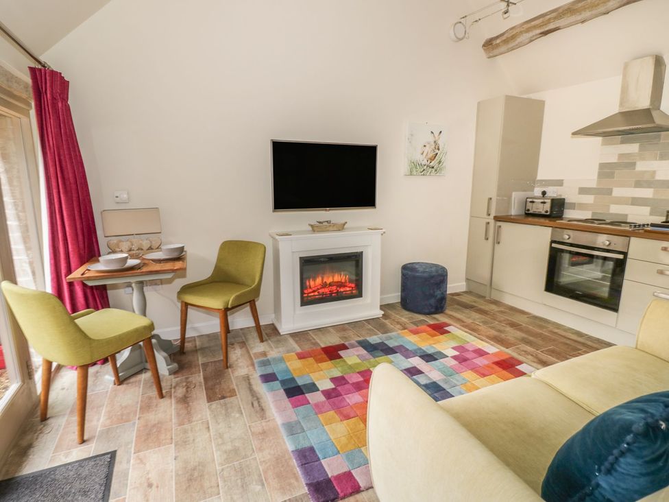A living room with a sofa and a television at The Bolt Hole in Stratford-upon-Avon