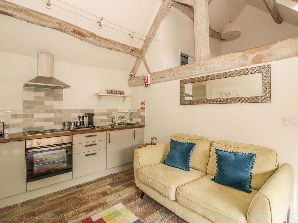 A kitchen with a couch and cooker at The Bolt Hole in Stratford-upon-Avon