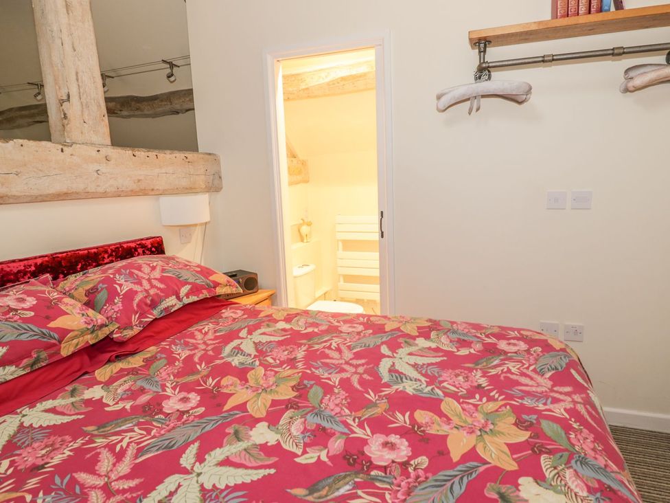 A bedroom with a bed and a door leading to a bathroom at The Bolt Hole in Stratford-upon-Avon