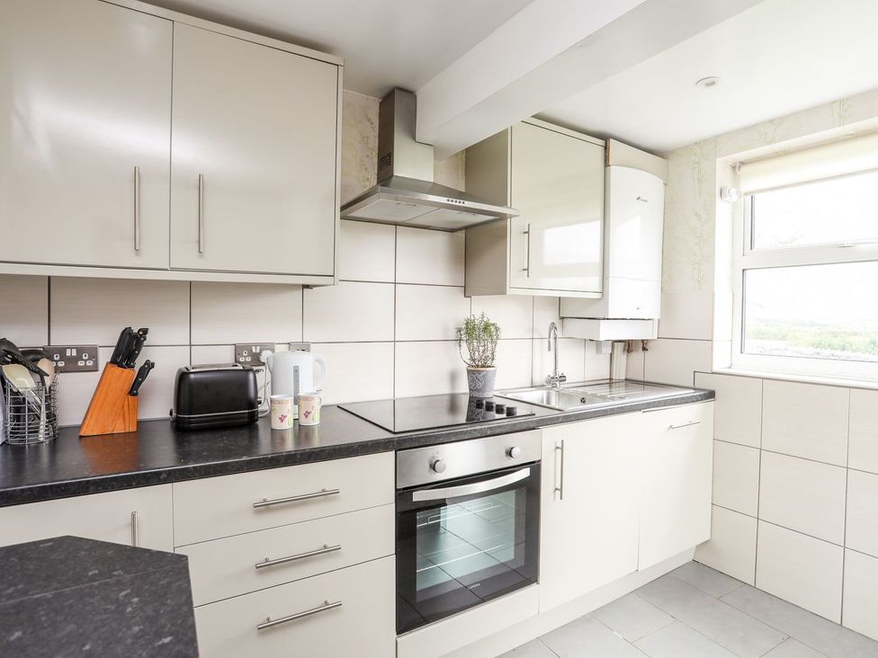 A kitchen featuring appliances and fixtures at Bodlasan Groes Cottage in Holyhead