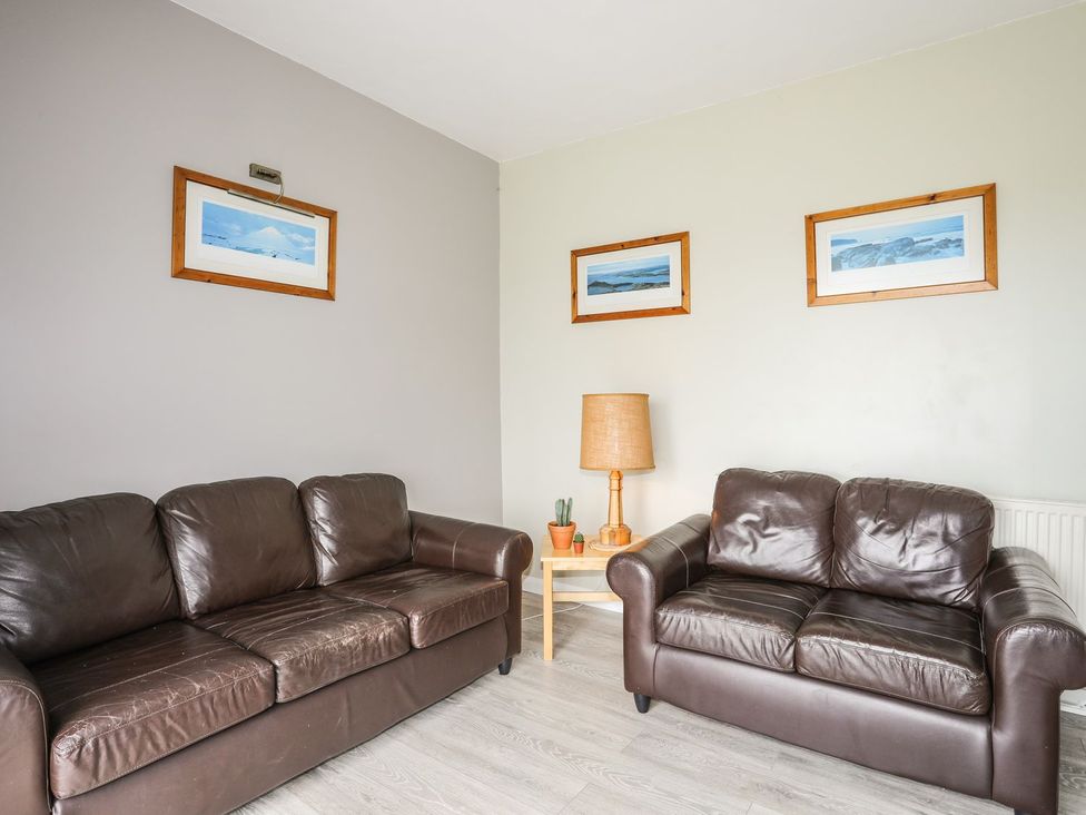 A living room with two sofas and a lamp at Bodlasan Groes House in Holyhead