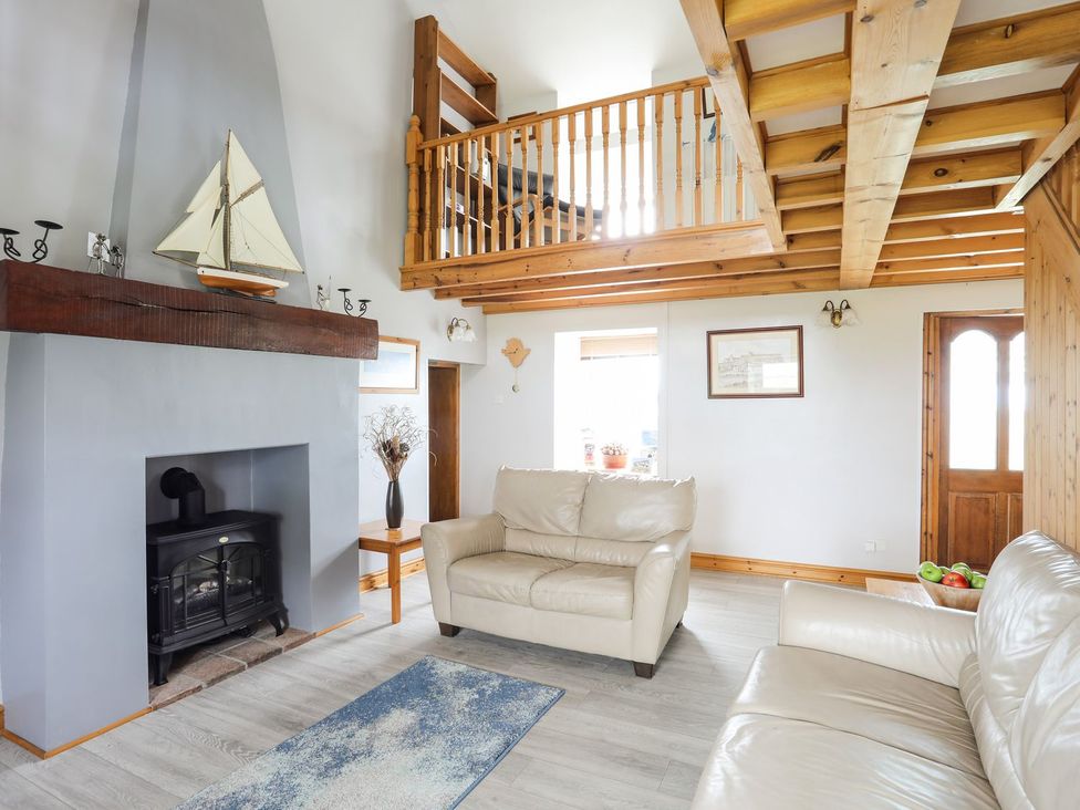 A living room with a sofa and a fireplace at Bodlasan Groes House in Holyhead