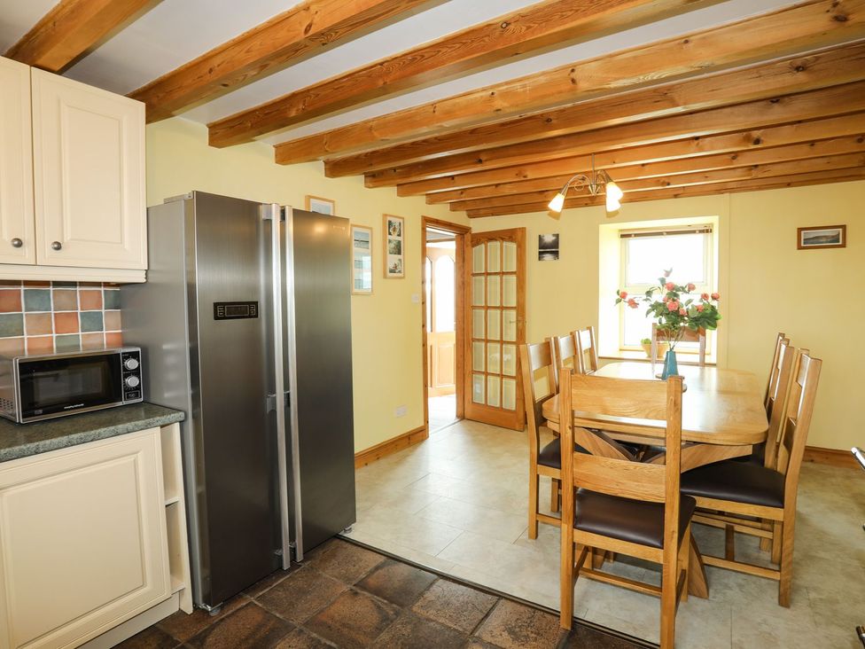A kitchen with a dining table and chairs at Bodlasan Groes House in Holyhead