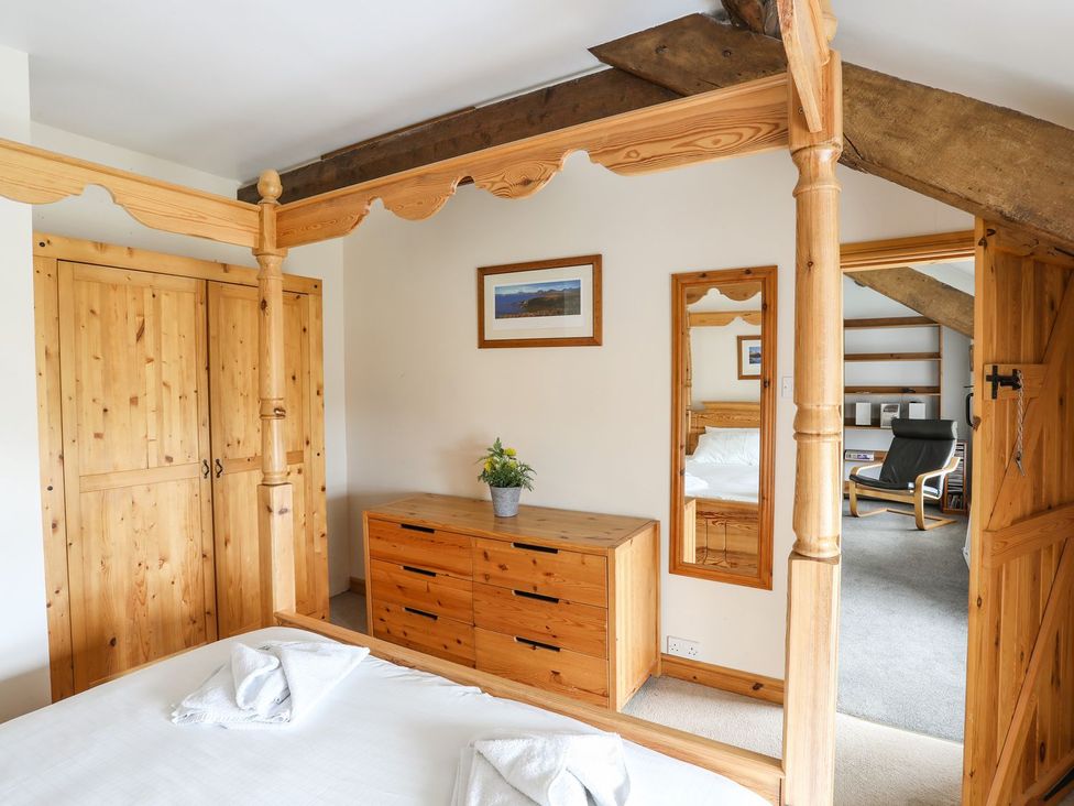 A bedroom with wooden furniture and a mirror at Bodlasan Groes House in Holyhead