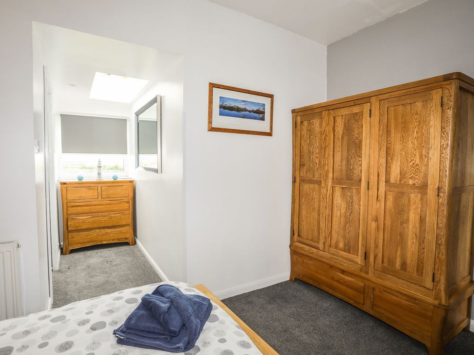 A bedroom with a wardrobe and a drawer at Bodlasan Groes House in Holyhead