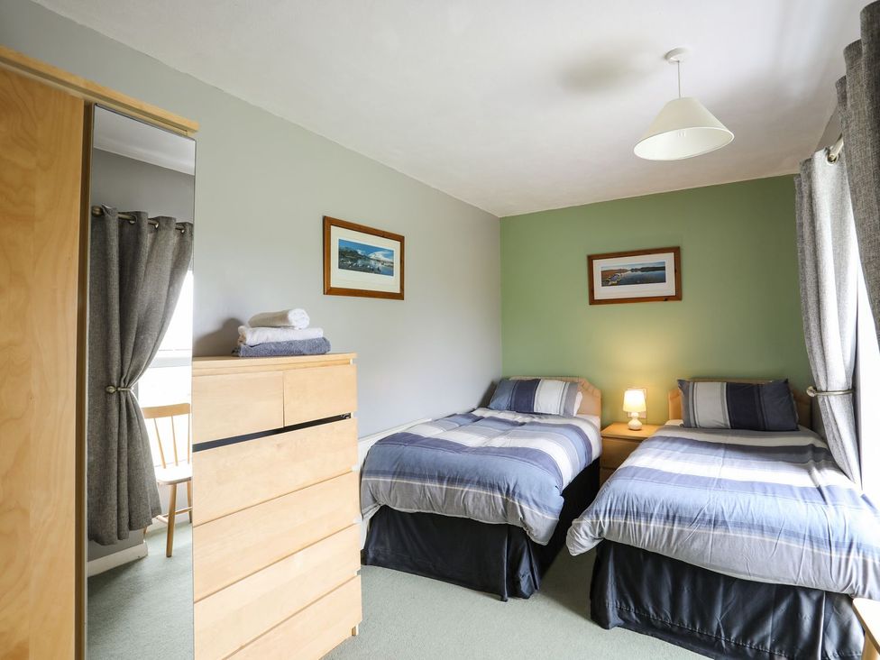 A bedroom with two beds and a lamp at Bodlasan Groes House in Holyhead